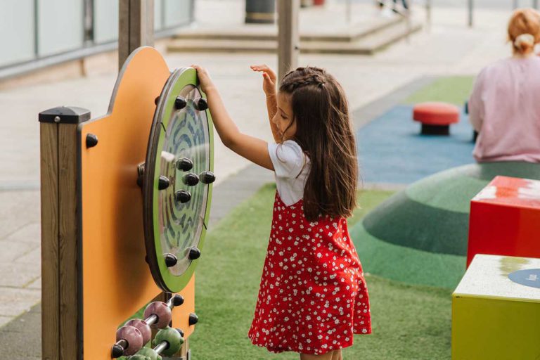 a girl is playing with a wheel on the playground