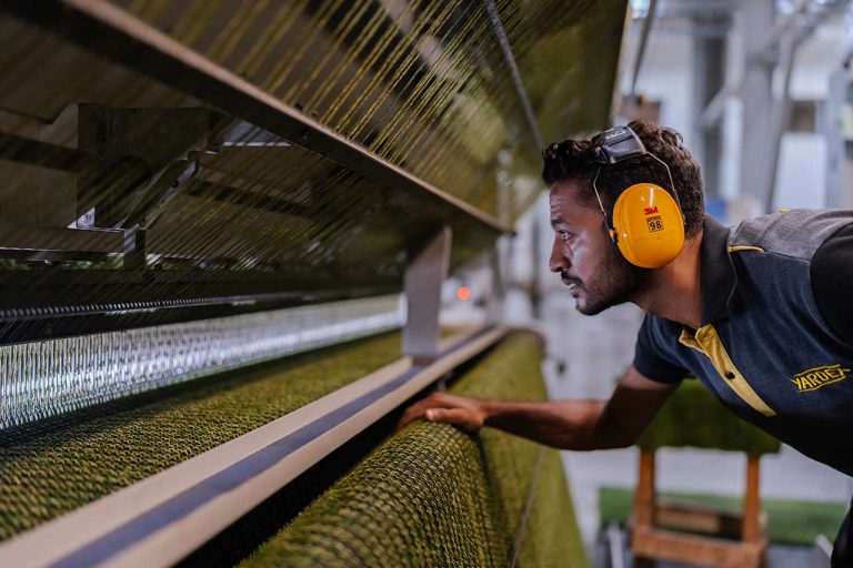 employee at the artificial grass machine