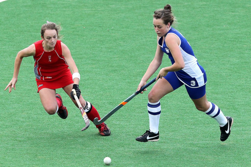 two players play hockey on artificial turf